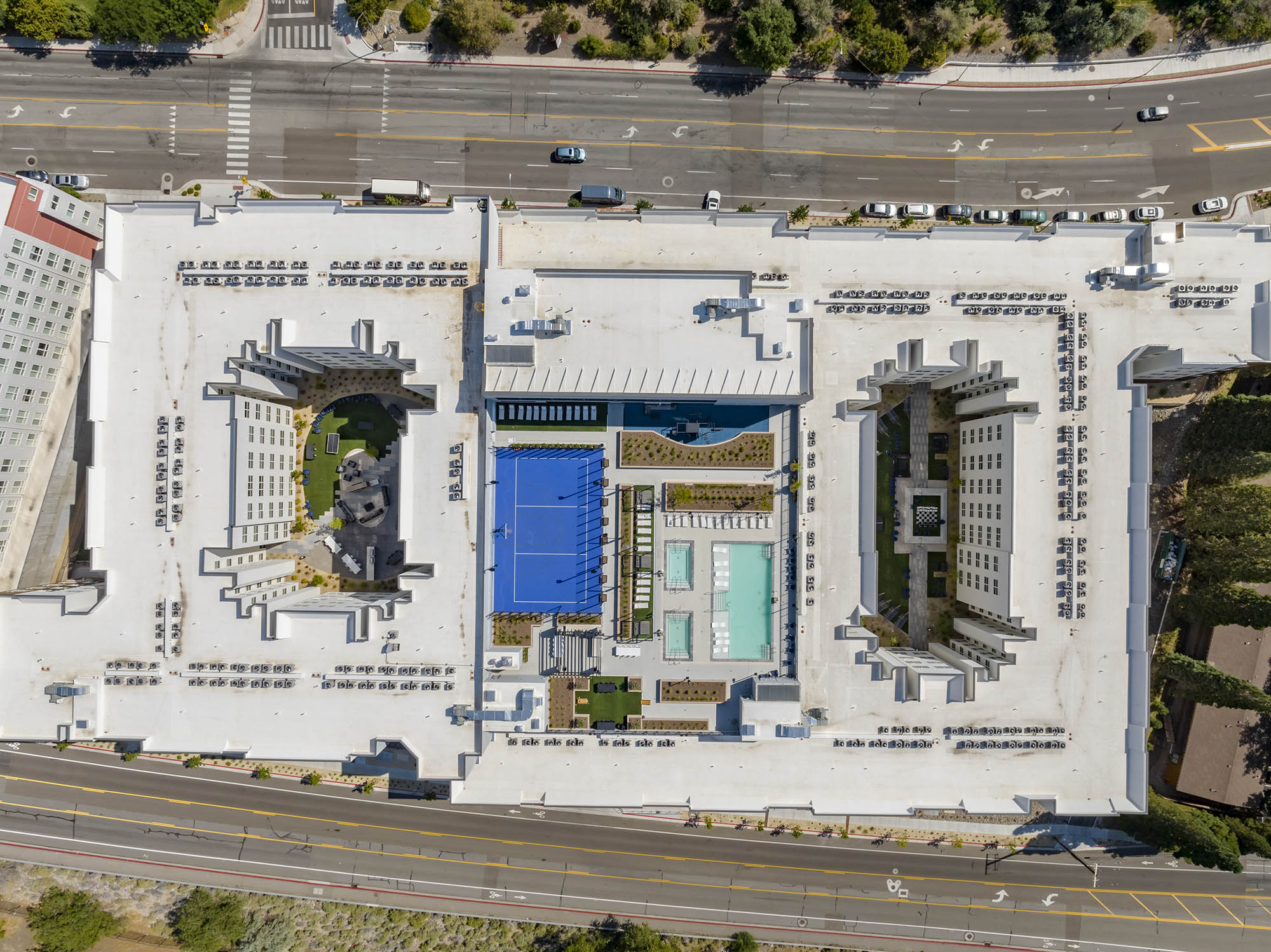 Aerial view of a hotel complex with pools and landscaped areas