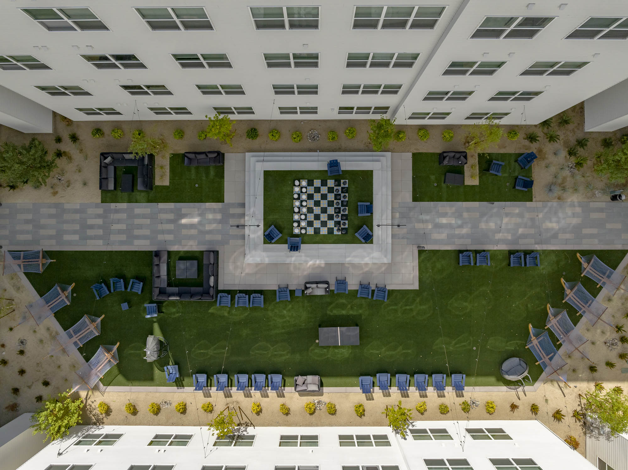 Aerial view of a landscaped courtyard with seating areas and a chessboard