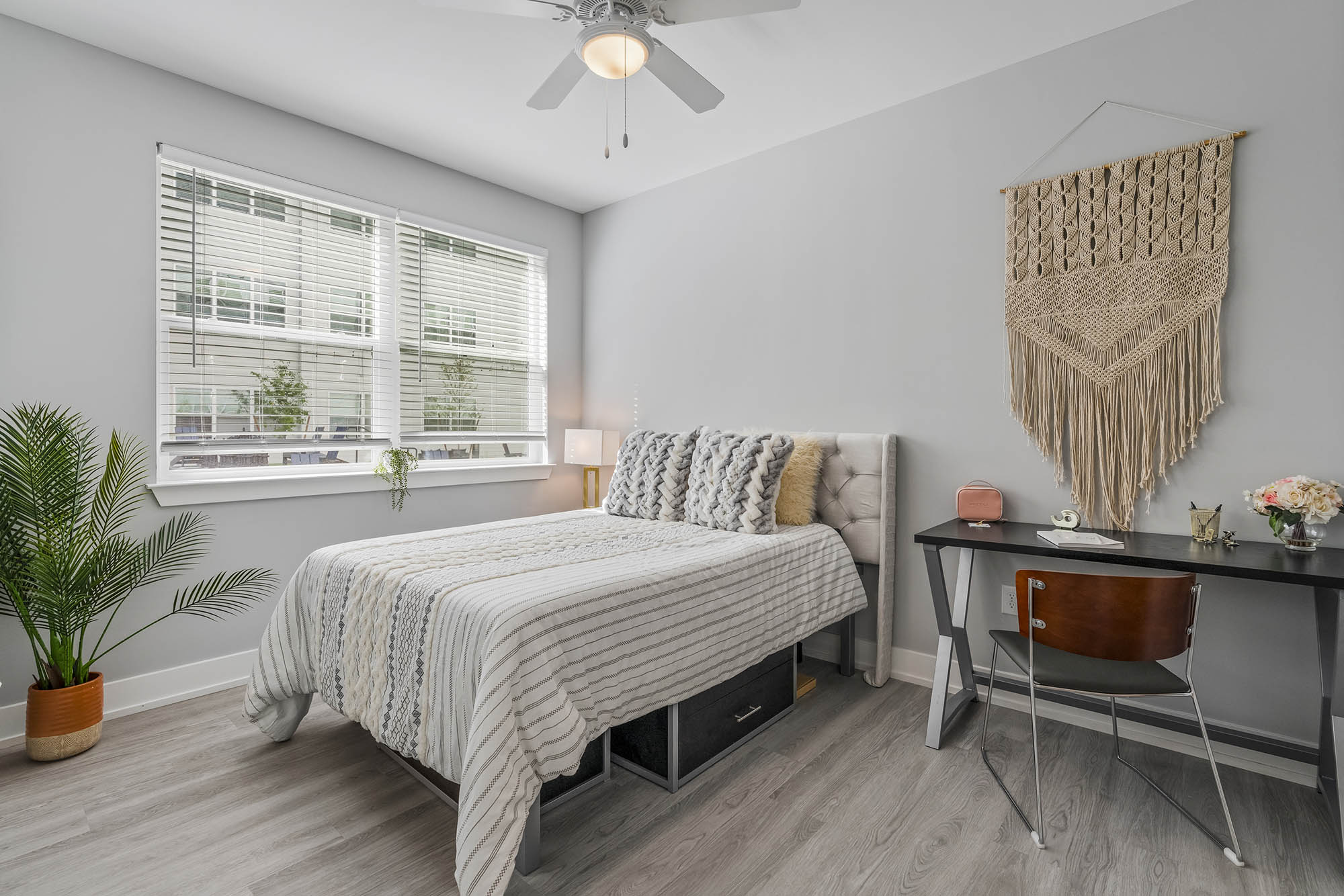Modern bedroom with a bed desk and decorative wall hanging