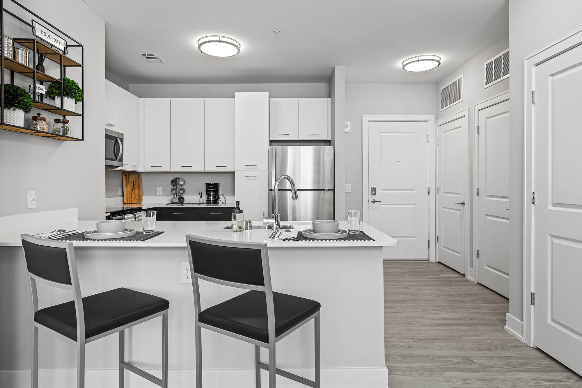 Modern kitchen with bar stools stainless steel appliances and minimalist decor