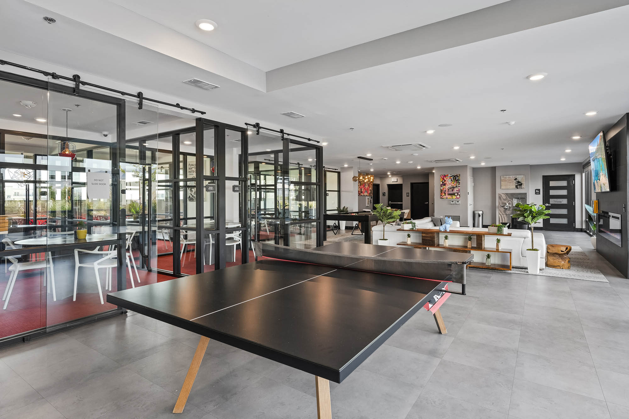 Modern lounge area featuring a ping pong table and seating