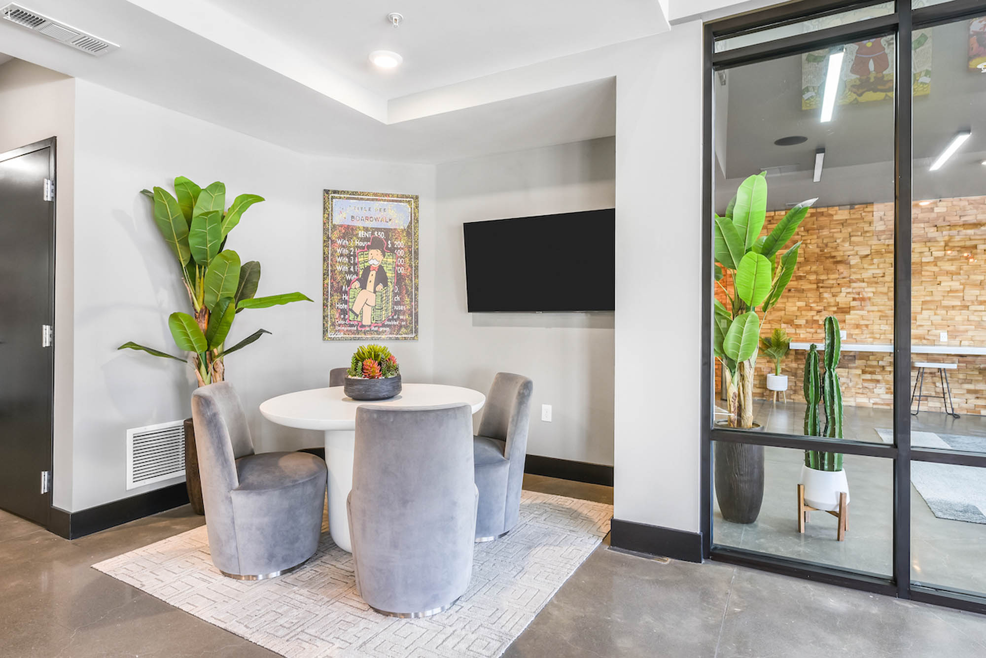 Modern seating area with round table potted plants and wall art