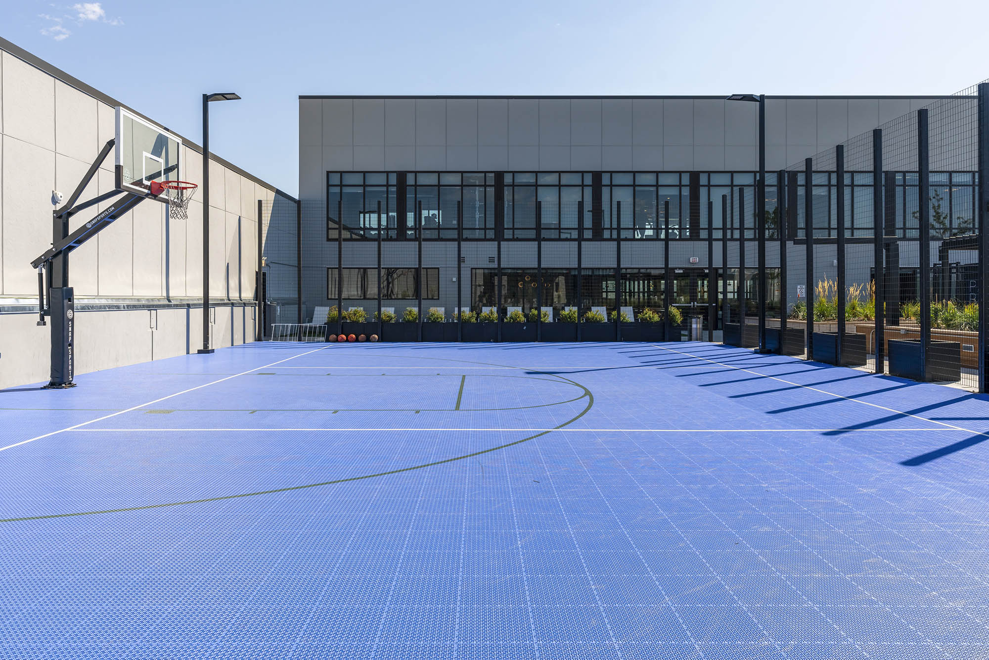 a brightly lit basketball court with a blue floor