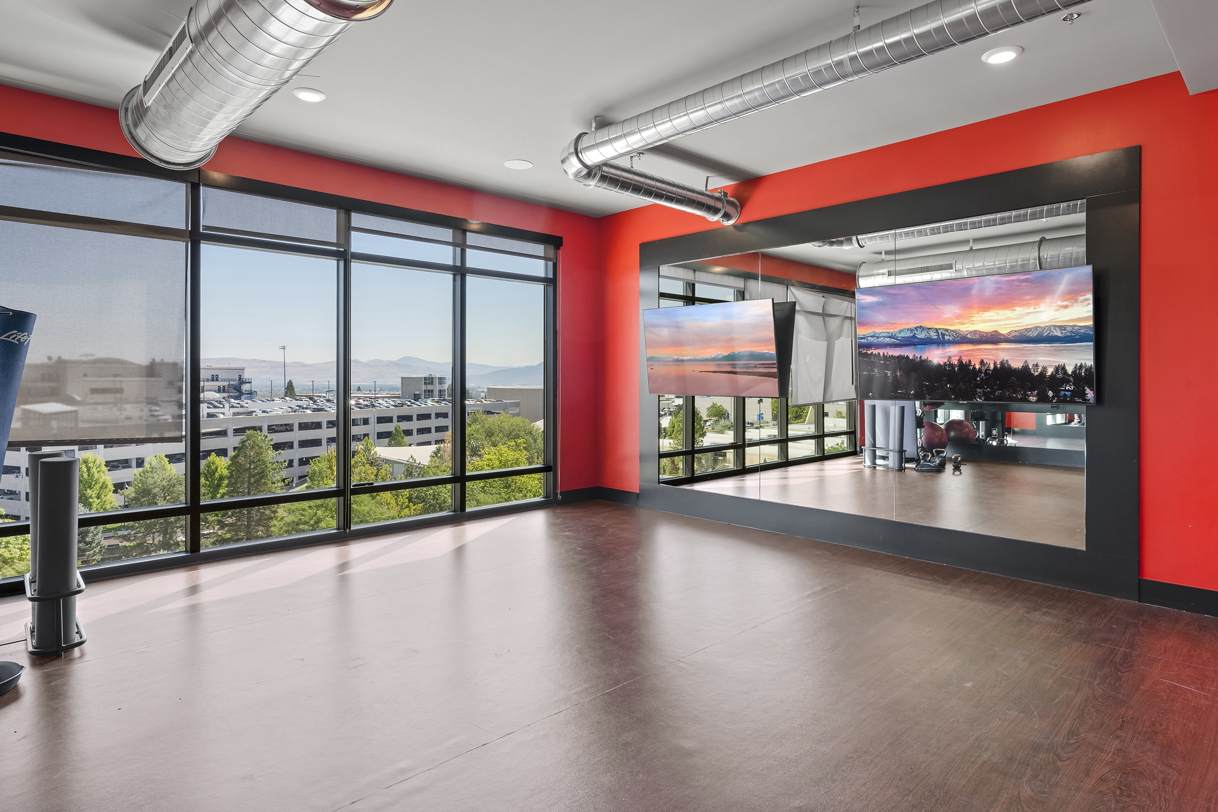 a modern exercise room with large windows mountai