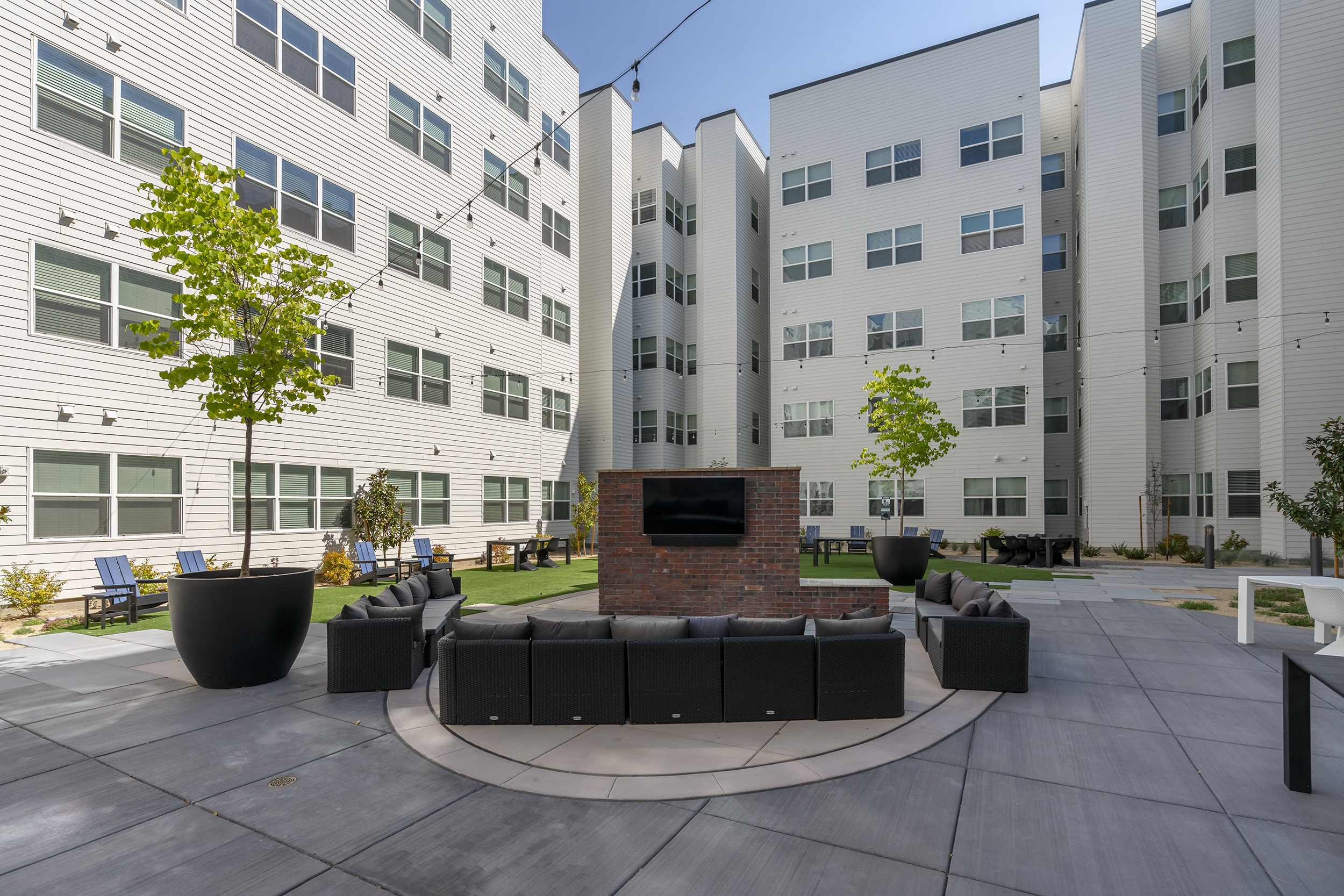 courtyard with modern seating greenery and a tv