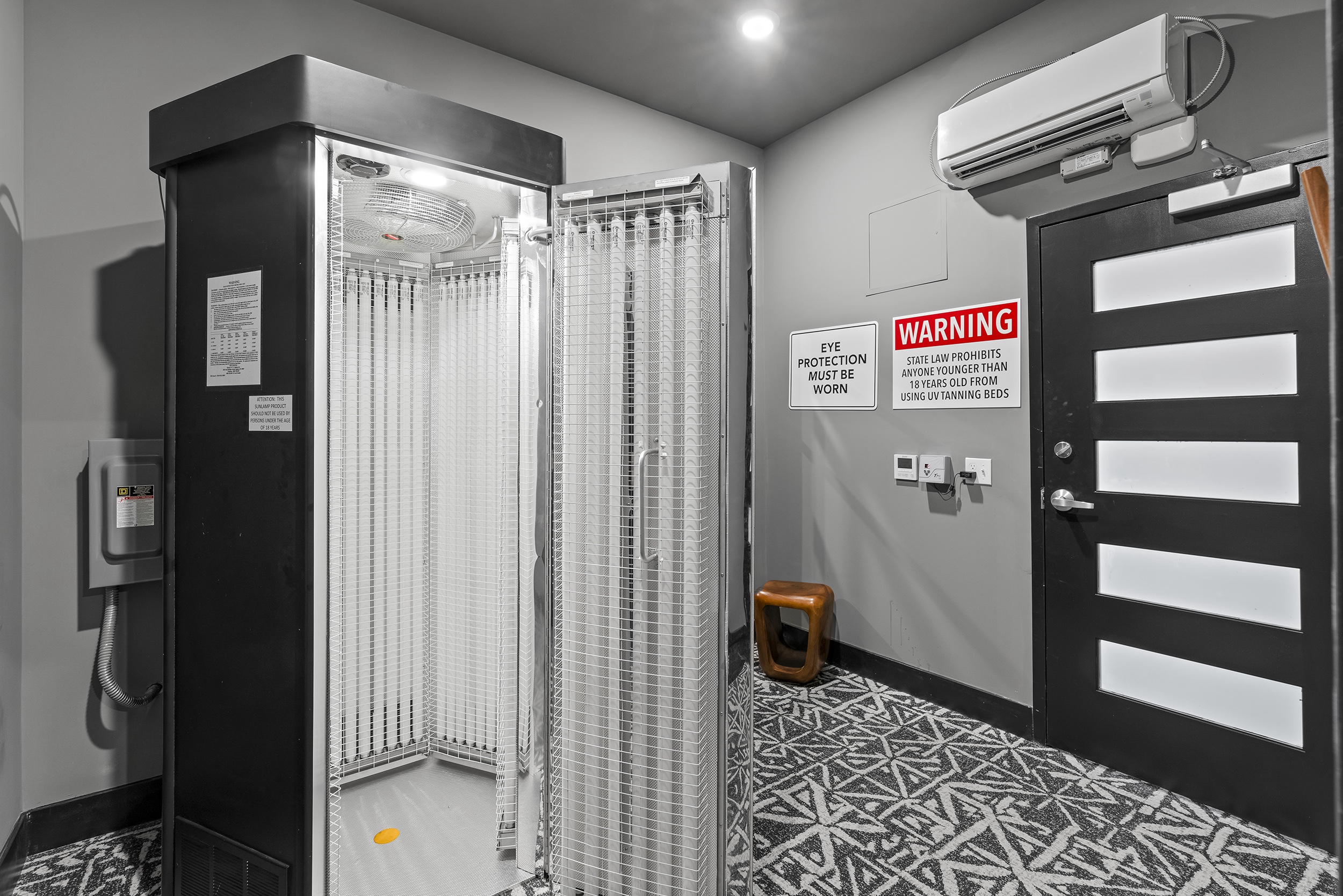 indoor tanning booth with warning signs a ventila