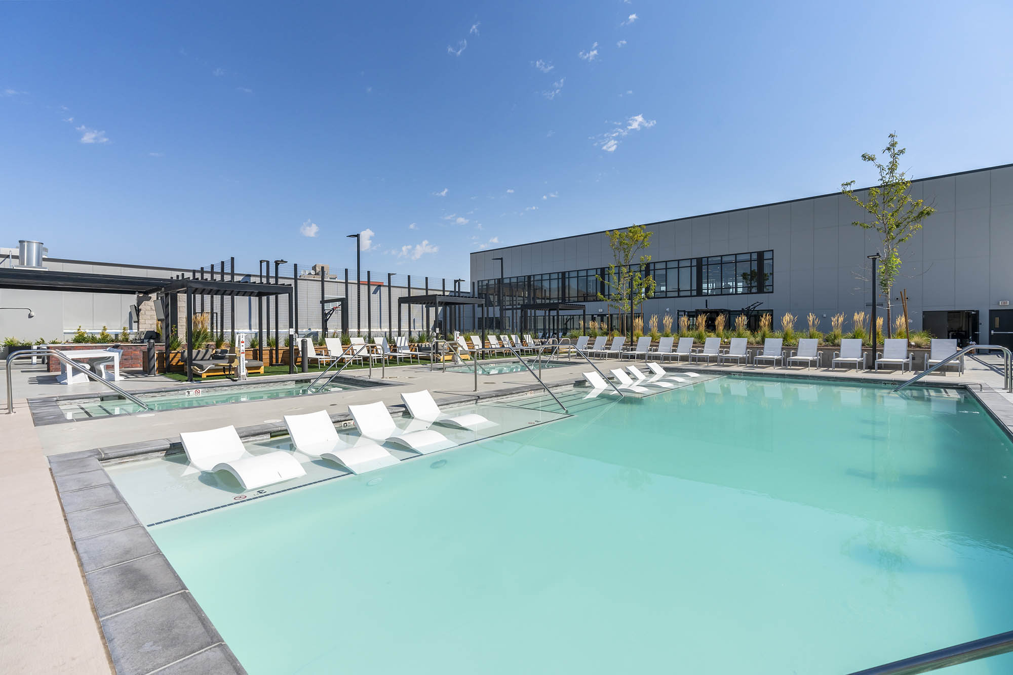 modern pool area with lounge chairs greenery and