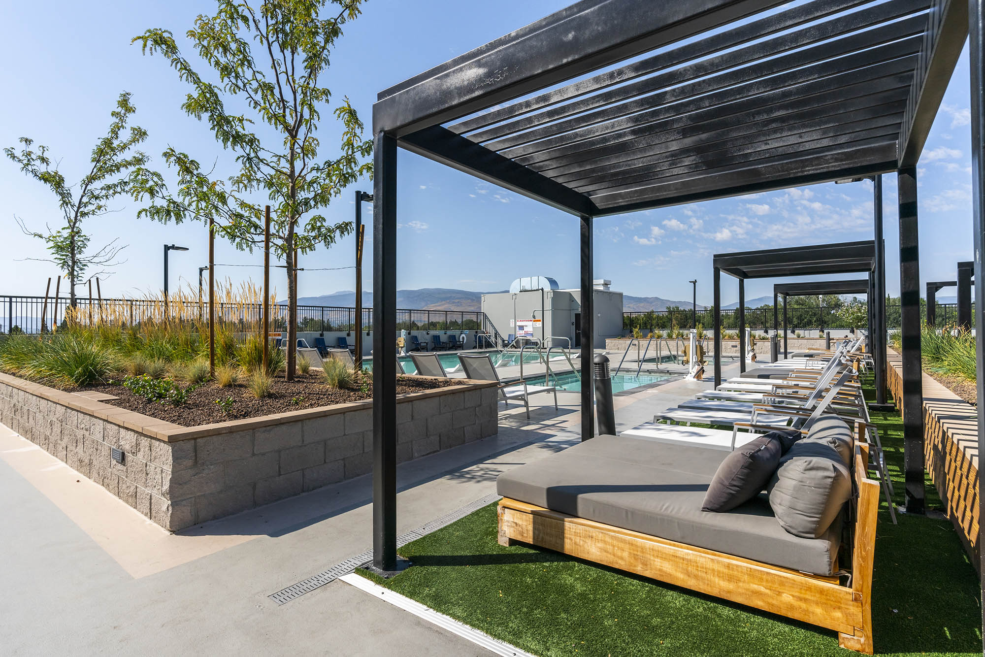 modern poolside area featuring lounge beds greene