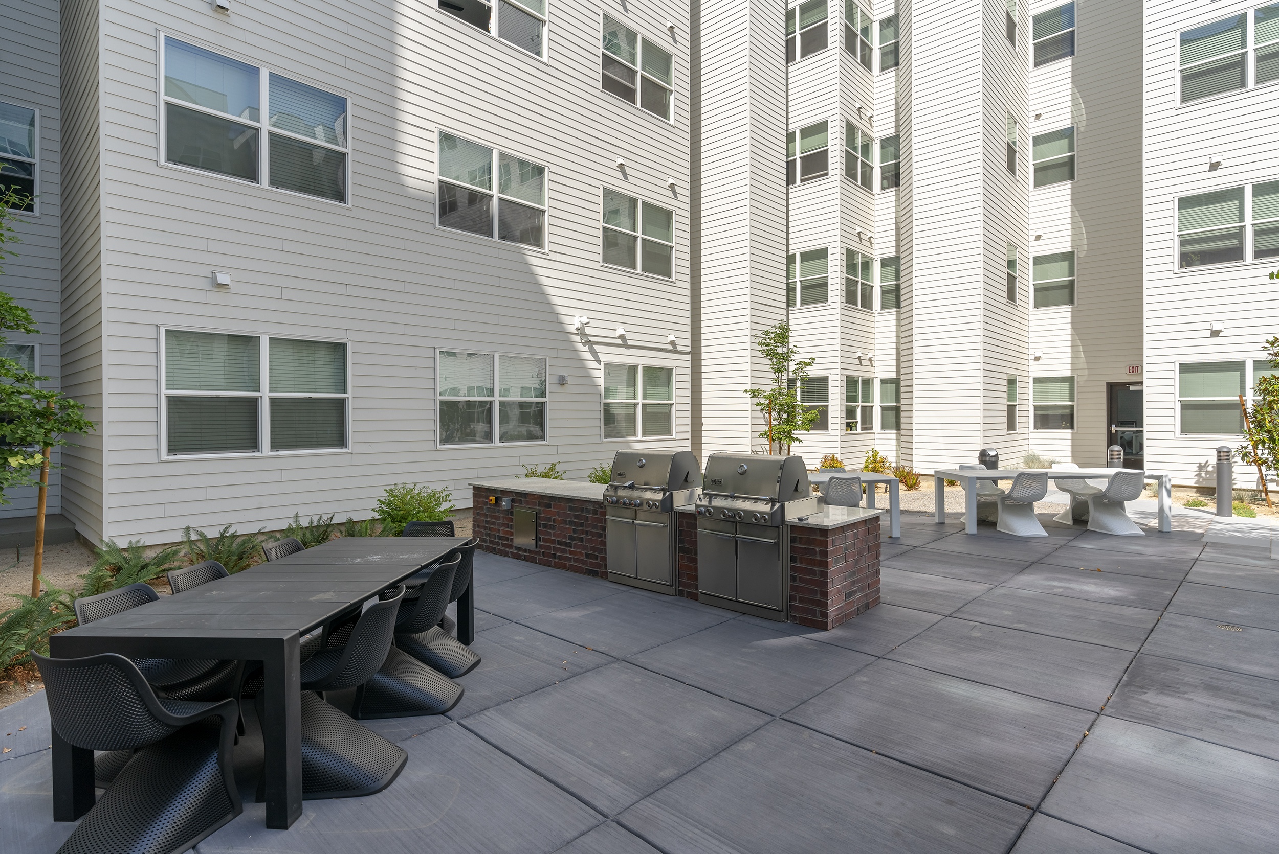outdoor patio area with a long table black chairs