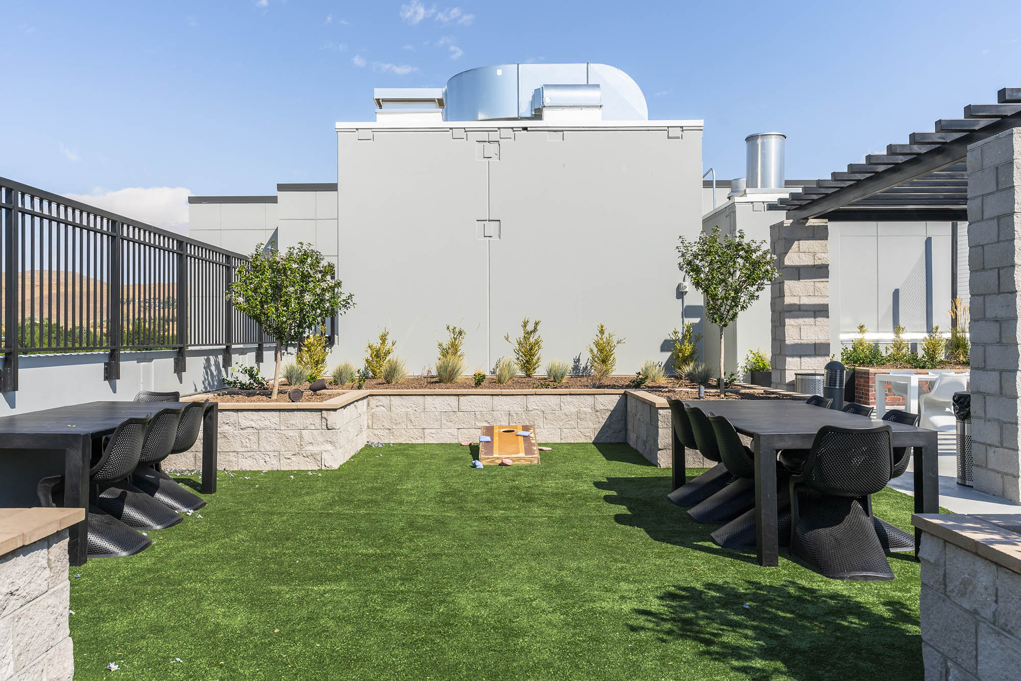 rooftop terrace with green turf black dining tabl